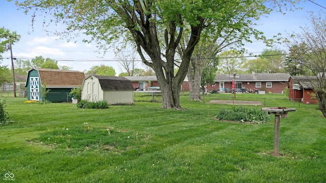 view of yard with fence, an outbuilding, and a shed