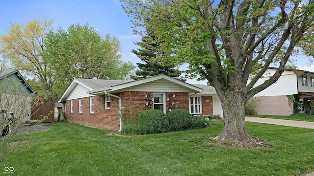ranch-style home featuring brick siding, a garage, and a front lawn