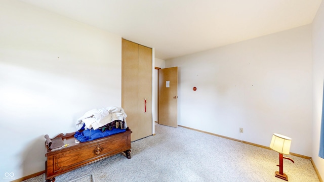 interior space featuring baseboards and light colored carpet