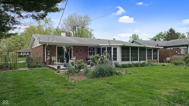 back of house featuring a yard, fence, and a sunroom