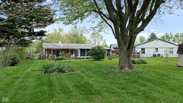 view of yard with central air condition unit and fence