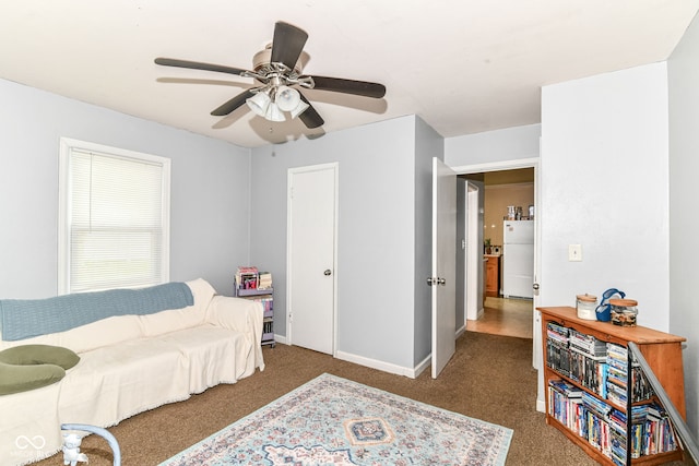 living room with carpet floors, baseboards, and ceiling fan