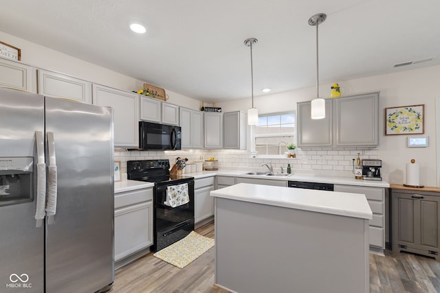 5845 Cresswell Ln, Whitestown, IN 46075 - kitchen featuring black appliances, backsplash, wood finished floors, light countertops, and recessed lighting