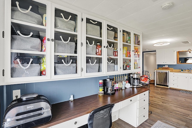 interior space with stainless steel dishwasher, visible vents, butcher block counters, white cabinetry, and a sink