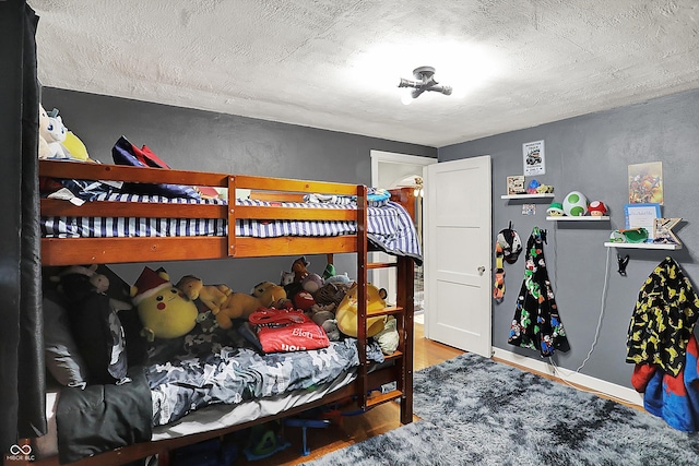bedroom featuring a textured ceiling and wood finished floors