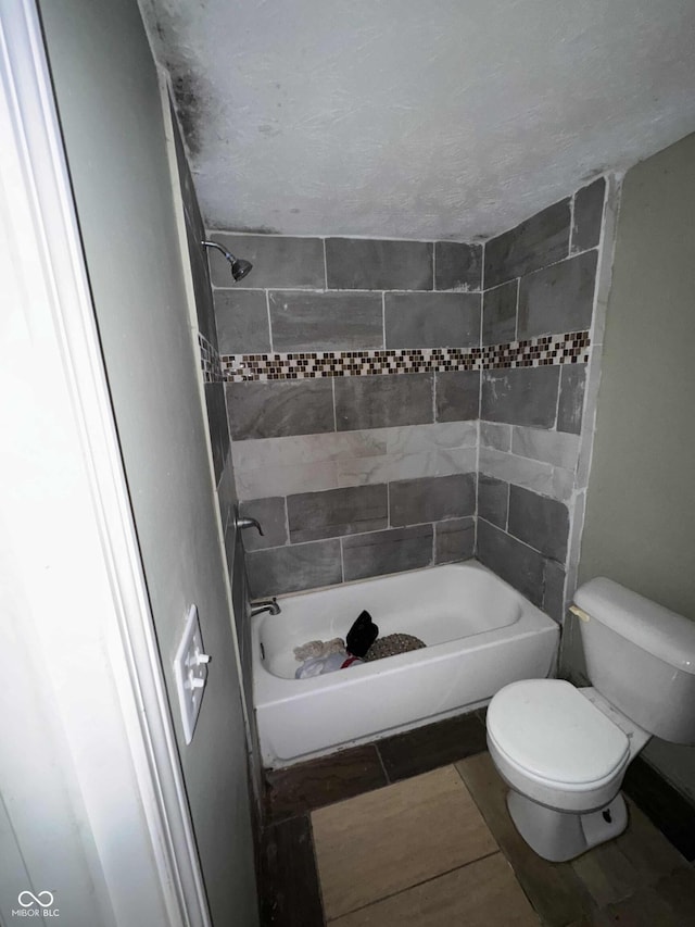 bathroom with bathing tub / shower combination, tile patterned floors, and toilet