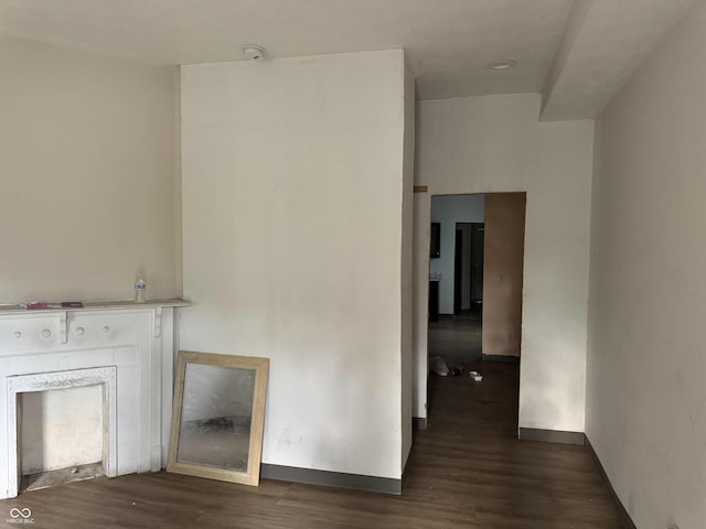 unfurnished living room featuring baseboards and wood finished floors