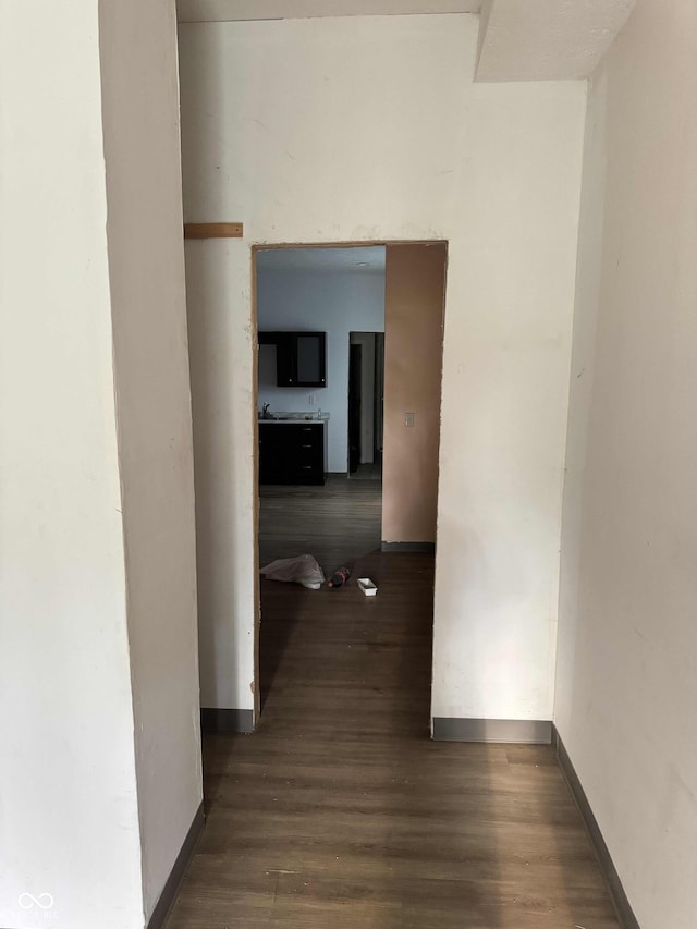 hall with baseboards and wood finished floors