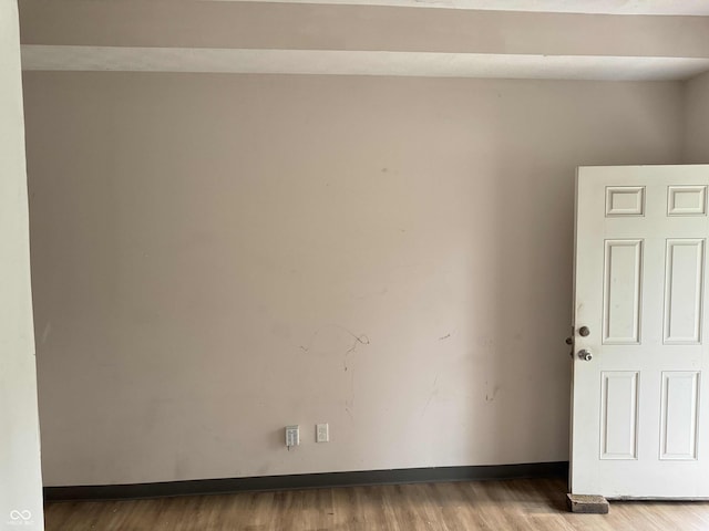 empty room featuring baseboards and wood finished floors
