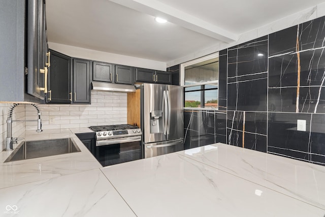 2263 N Rural St, Indianapolis, IN 46218 - kitchen with stainless steel appliances, a sink, under cabinet range hood, tasteful backsplash, and light stone counters