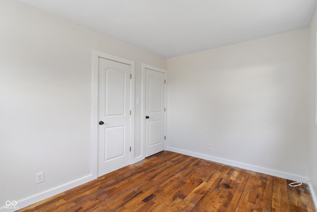 2263 N Rural St, Indianapolis, IN 46218 - unfurnished bedroom with baseboards and dark wood finished floors