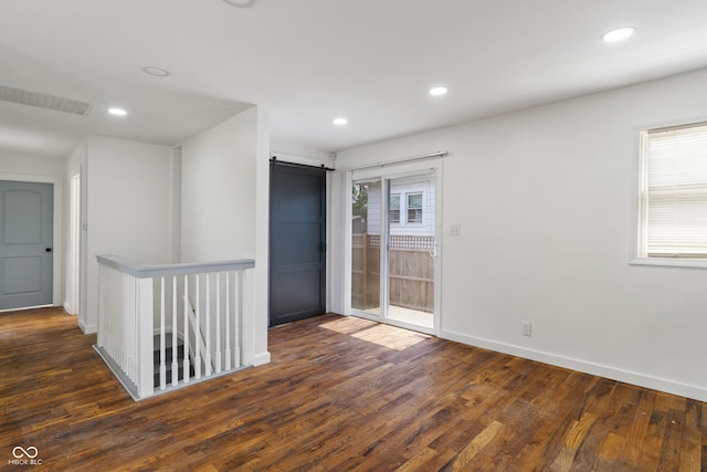 2263 N Rural St, Indianapolis, IN 46218 - unfurnished room with a barn door, wood finished floors, recessed lighting, and baseboards