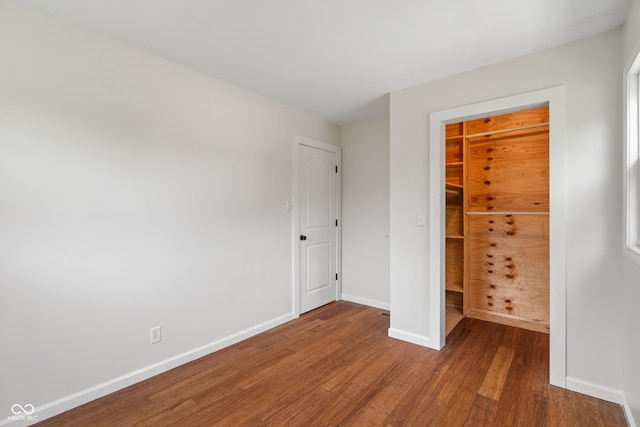 2263 N Rural St, Indianapolis, IN 46218 - unfurnished bedroom with wood finished floors, baseboards, a closet, and a spacious closet