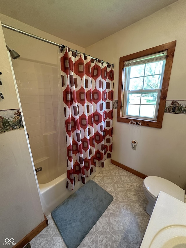 bathroom with shower / bath combo with shower curtain, baseboards, and toilet