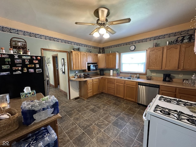 kitchen with light countertops, a ceiling fan, appliances with stainless steel finishes, and a sink