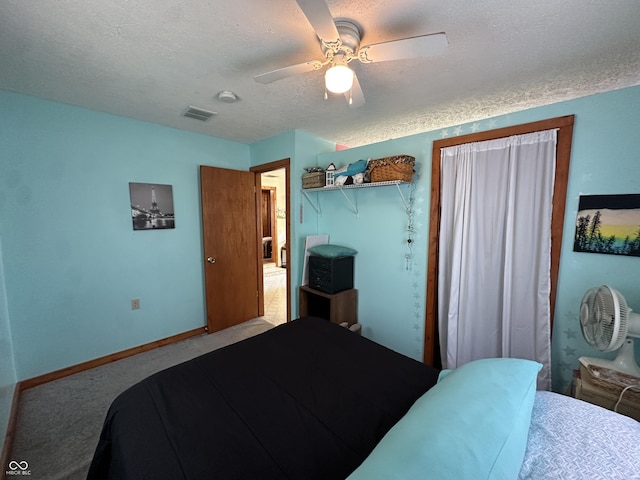 bedroom featuring ceiling fan, a textured ceiling, visible vents, baseboards, and carpet