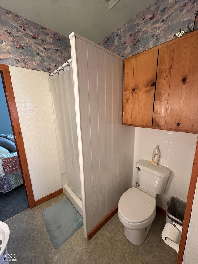 bathroom with a shower stall, wallpapered walls, and toilet