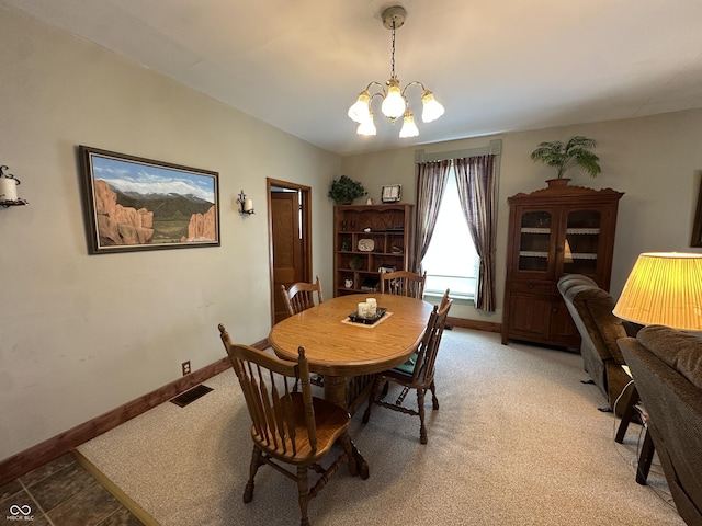 dining room with a notable chandelier, visible vents, light carpet, and baseboards