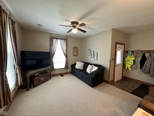 living room featuring baseboards, ceiling fan, and carpet flooring