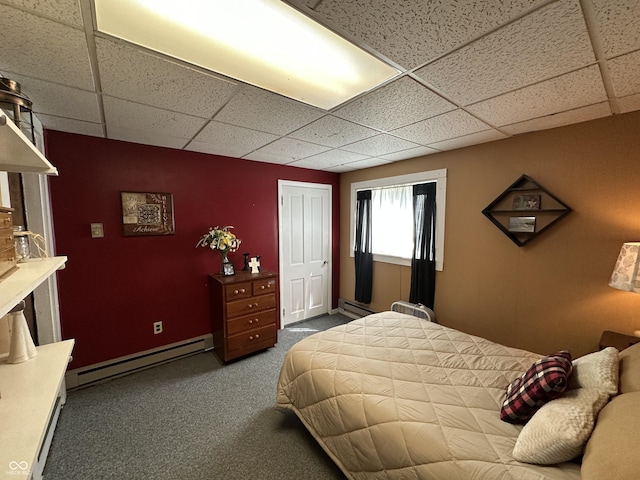 bedroom featuring dark colored carpet, a drop ceiling, and baseboard heating