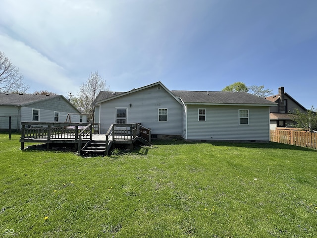 rear view of property featuring fence, a wooden deck, a yard, and crawl space