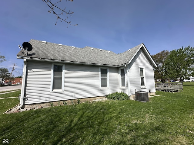 back of house with a lawn, cooling unit, a shingled roof, and a wooden deck
