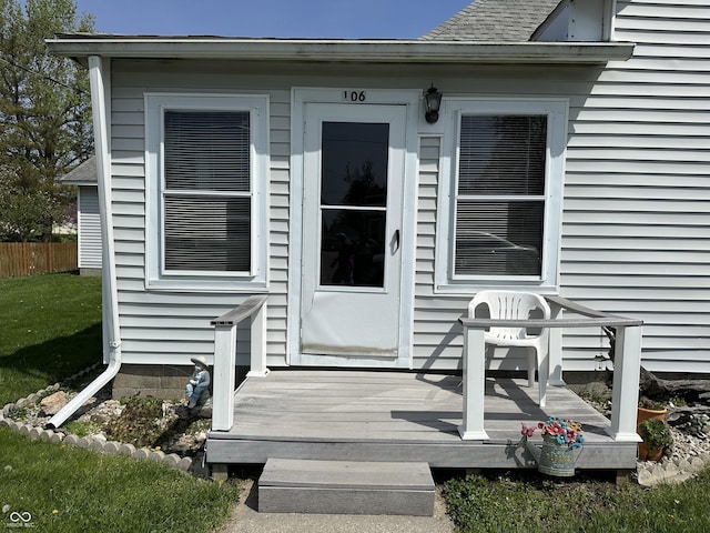 entrance to property with fence and a wooden deck