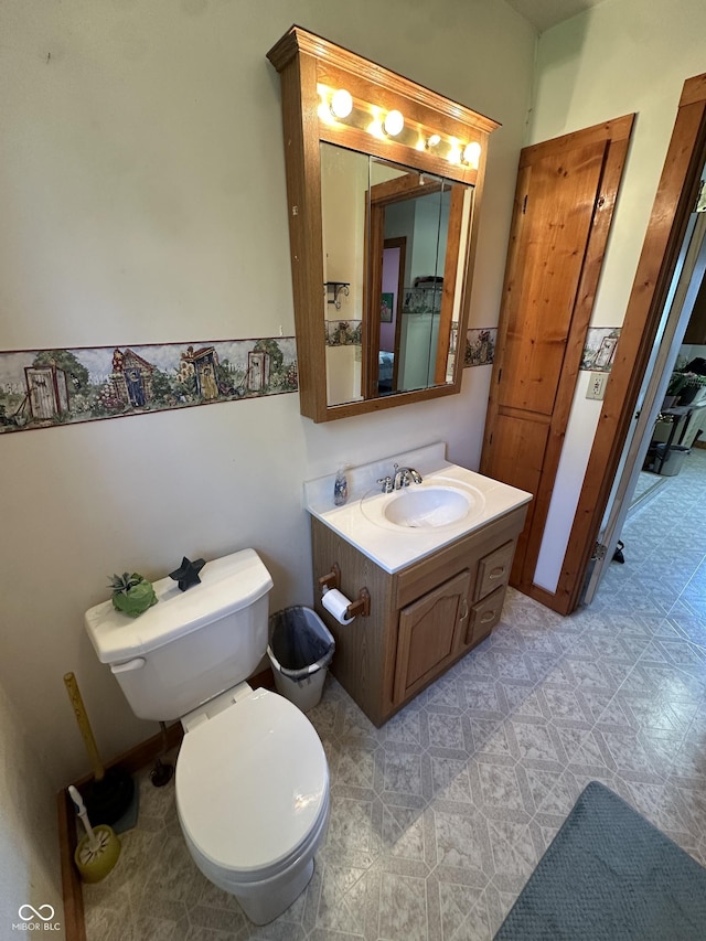 bathroom with toilet, tile patterned floors, and vanity