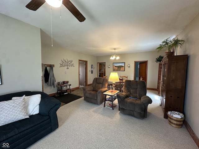living room featuring baseboards, carpet, and ceiling fan with notable chandelier