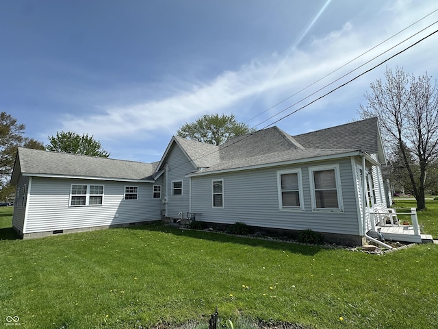 back of house featuring a lawn, roof with shingles, and crawl space