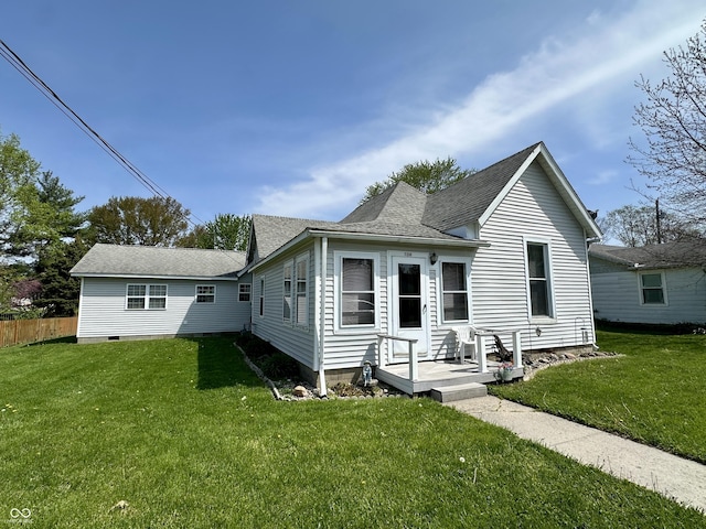 view of front of house featuring fence, roof with shingles, and a front lawn