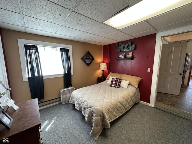 bedroom featuring carpet floors, a baseboard radiator, baseboards, and a drop ceiling