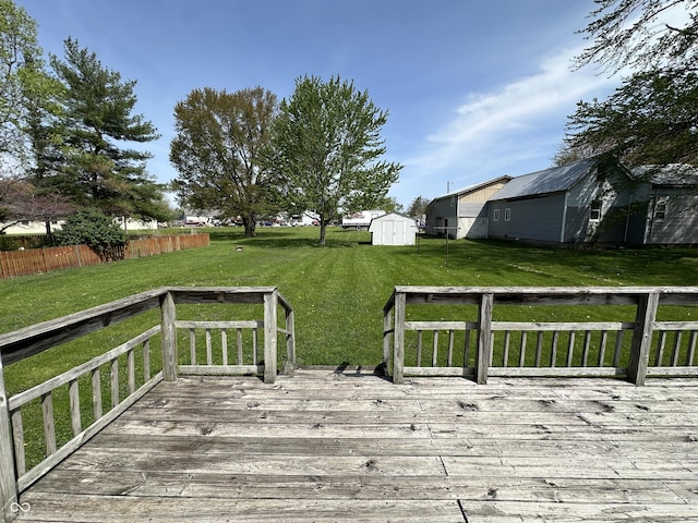 deck with a storage shed, a yard, and an outdoor structure