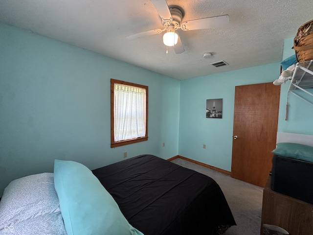 bedroom with carpet flooring, ceiling fan, a textured ceiling, baseboards, and visible vents