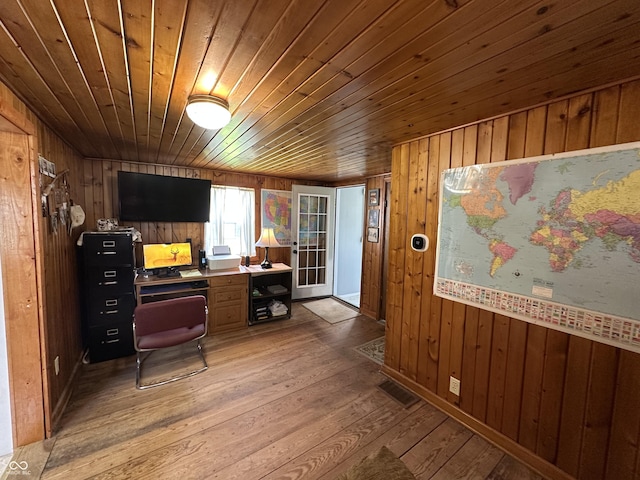 office with wood ceiling, wood walls, light wood-style flooring, and visible vents
