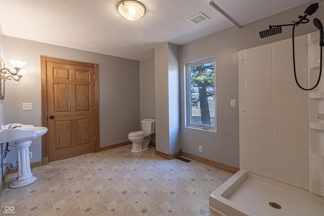 full bathroom with visible vents, toilet, baseboards, a shower stall, and a sink