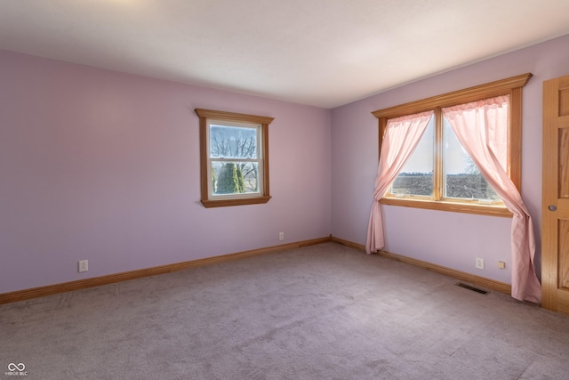 unfurnished room with carpet floors, baseboards, and visible vents