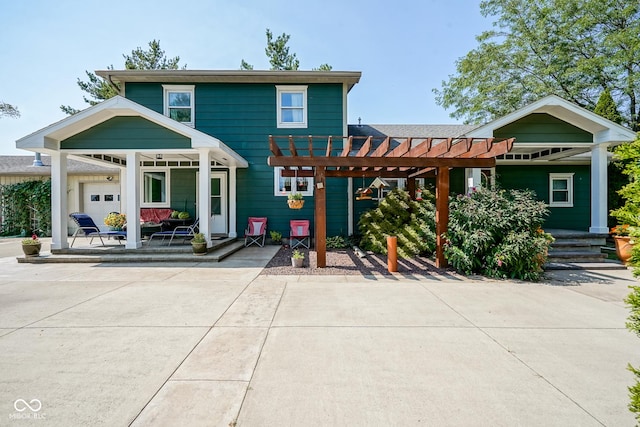 rear view of property with covered porch and a pergola