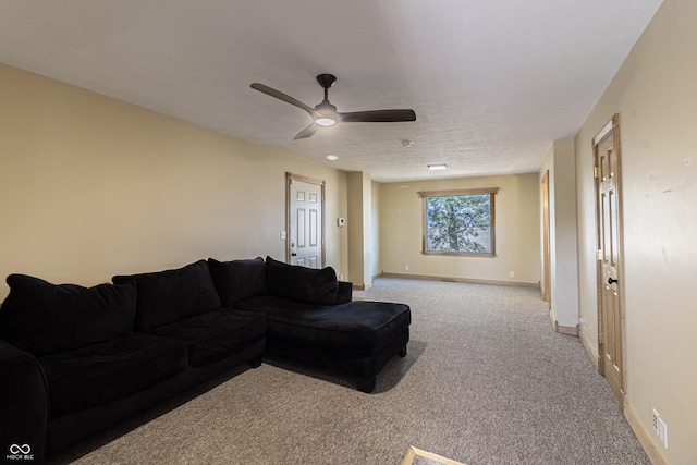 living room featuring baseboards, light carpet, and a ceiling fan