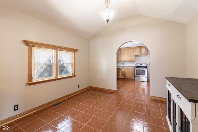 kitchen featuring visible vents, dark countertops, arched walkways, vaulted ceiling, and stainless steel range with electric cooktop