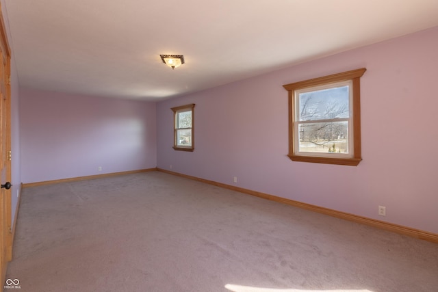 carpeted empty room featuring baseboards