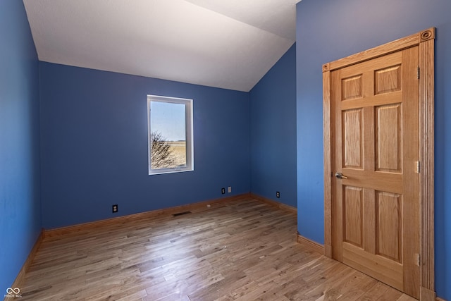 additional living space featuring baseboards, wood finished floors, and lofted ceiling