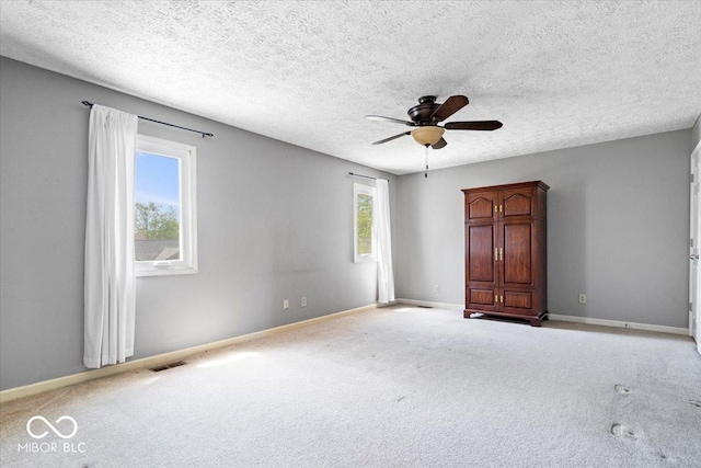 empty room with visible vents, baseboards, ceiling fan, and carpet floors