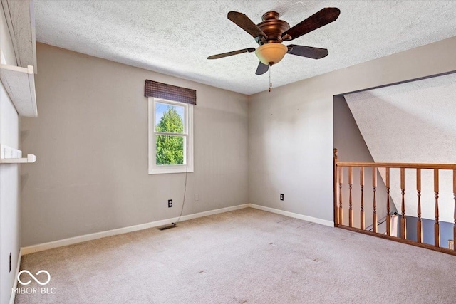 spare room featuring baseboards, a textured ceiling, carpet, and ceiling fan