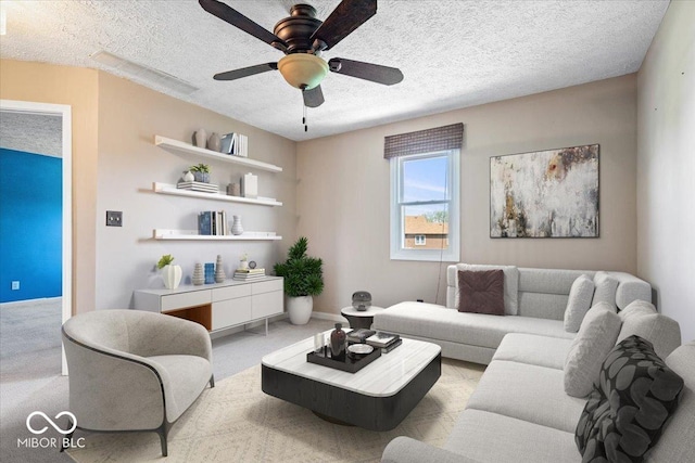living area featuring carpet floors, a ceiling fan, a textured ceiling, and baseboards