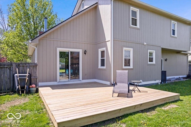 rear view of property featuring a yard, a deck, and fence