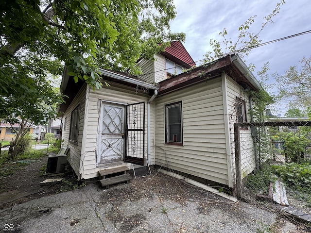 rear view of house featuring fence and central AC unit