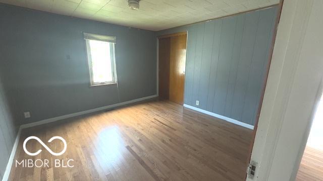unfurnished room with baseboards and wood finished floors