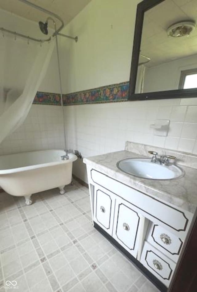 full bath with a freestanding bath, vanity, and a shower