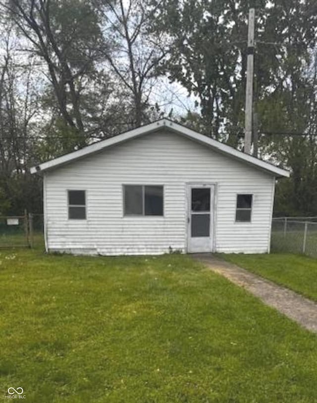 back of house with a lawn and fence